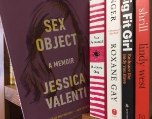 Image displays Sex Object tucked onto a wooden bookshelf but sticking out from the other books and hanging off the edge. Other books visible are other feminist works, including Bad Feminist by Roxane Gay and Shrill from Lindy West.